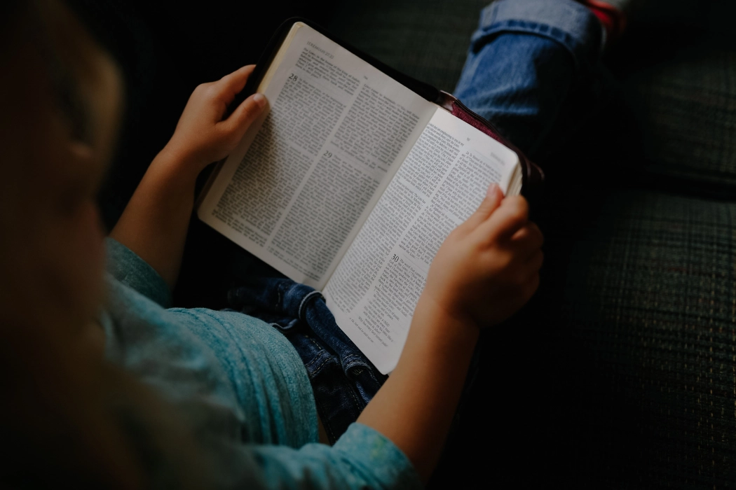 Young child reading the Bible.