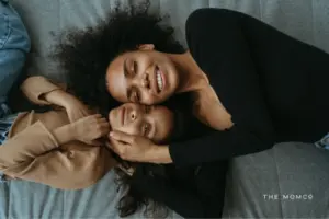 Mom laying with daughter on a bed